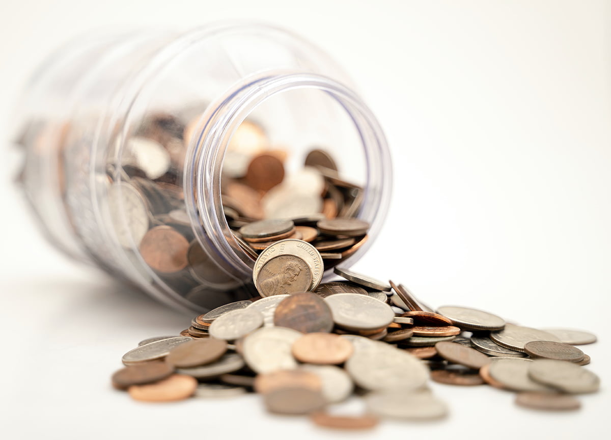 Save Money Budget-friendly website creation: A tilted jar full of coins.
